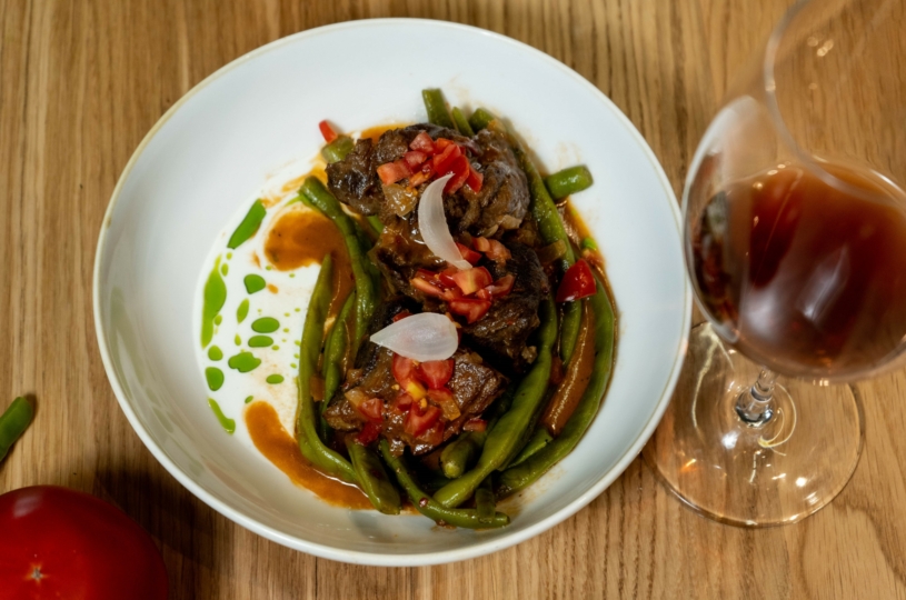 Male goat with green beans with a glass of Romeiko P.G.I. Crete