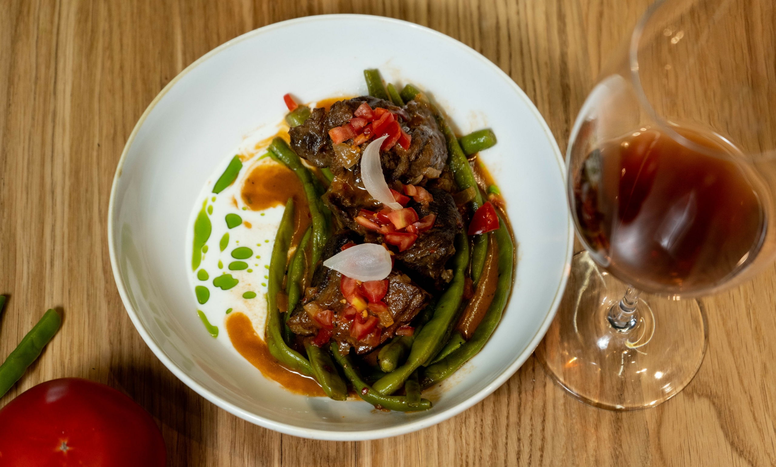 Male goat with green beans with a glass of Romeiko P.G.I. Crete