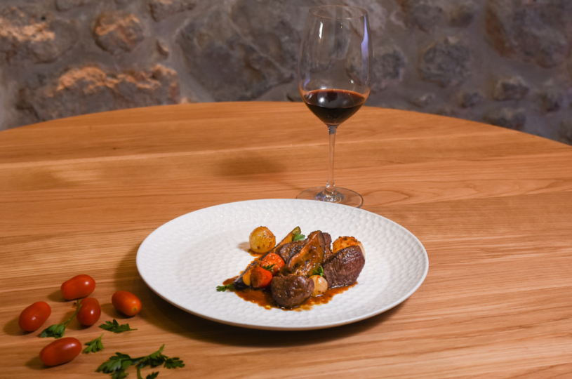 Beef and eggplant braised with tomato sauce with a glass of Mandilari P.G.I. Crete