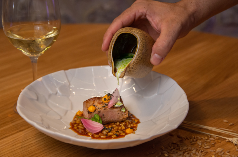 Pork collar butt with wheat, cumin and sour cream with a glass of Thrapsathiri P.G.I. Crete